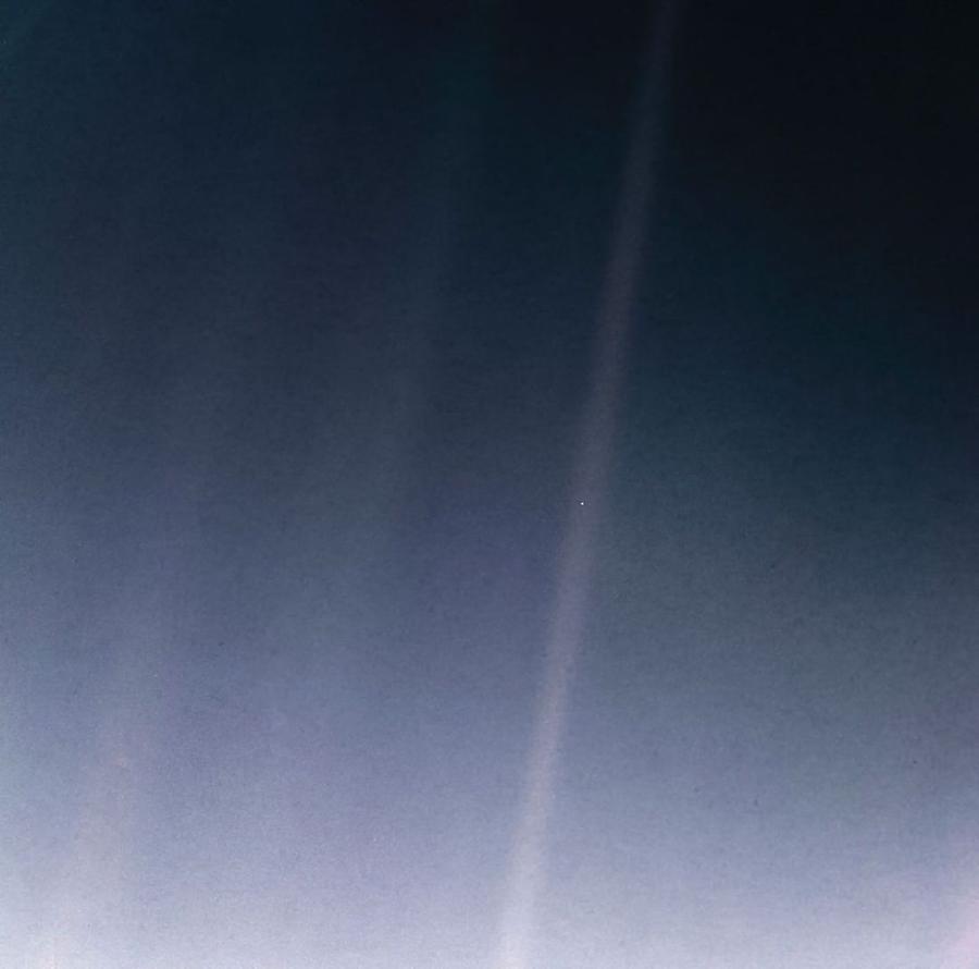 The Pale Blue Dot. Earth as a single luminous point in a beam of scattered sunlight, photographed by Voyager 1 in 1990.